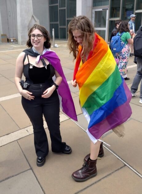 Monica and Georgie wearing the Pride and asexual flag