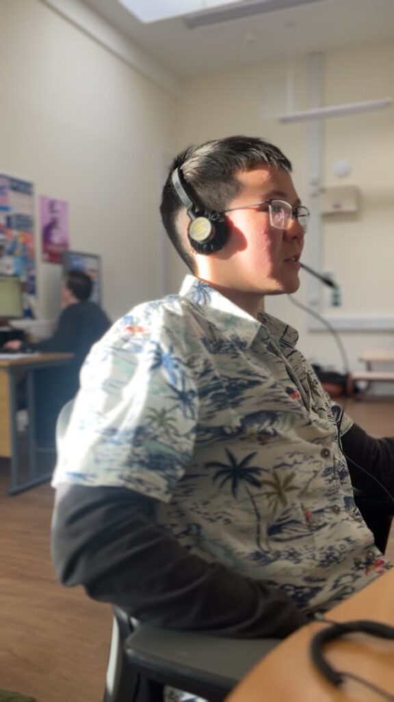 A volunteer in our helpline office with a headset providing support