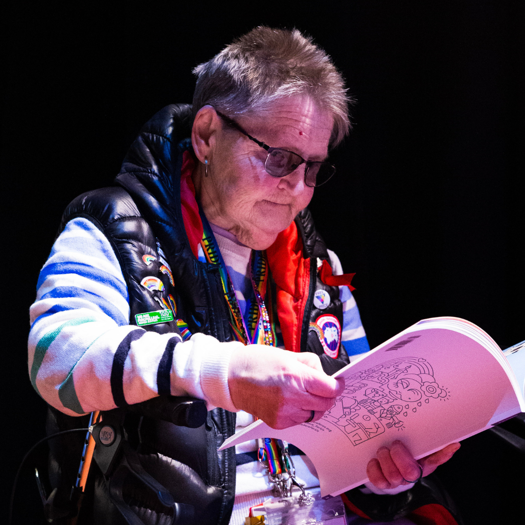 An older community member looking at a magazine at an event hosted by LGBT Health and Wellbeing