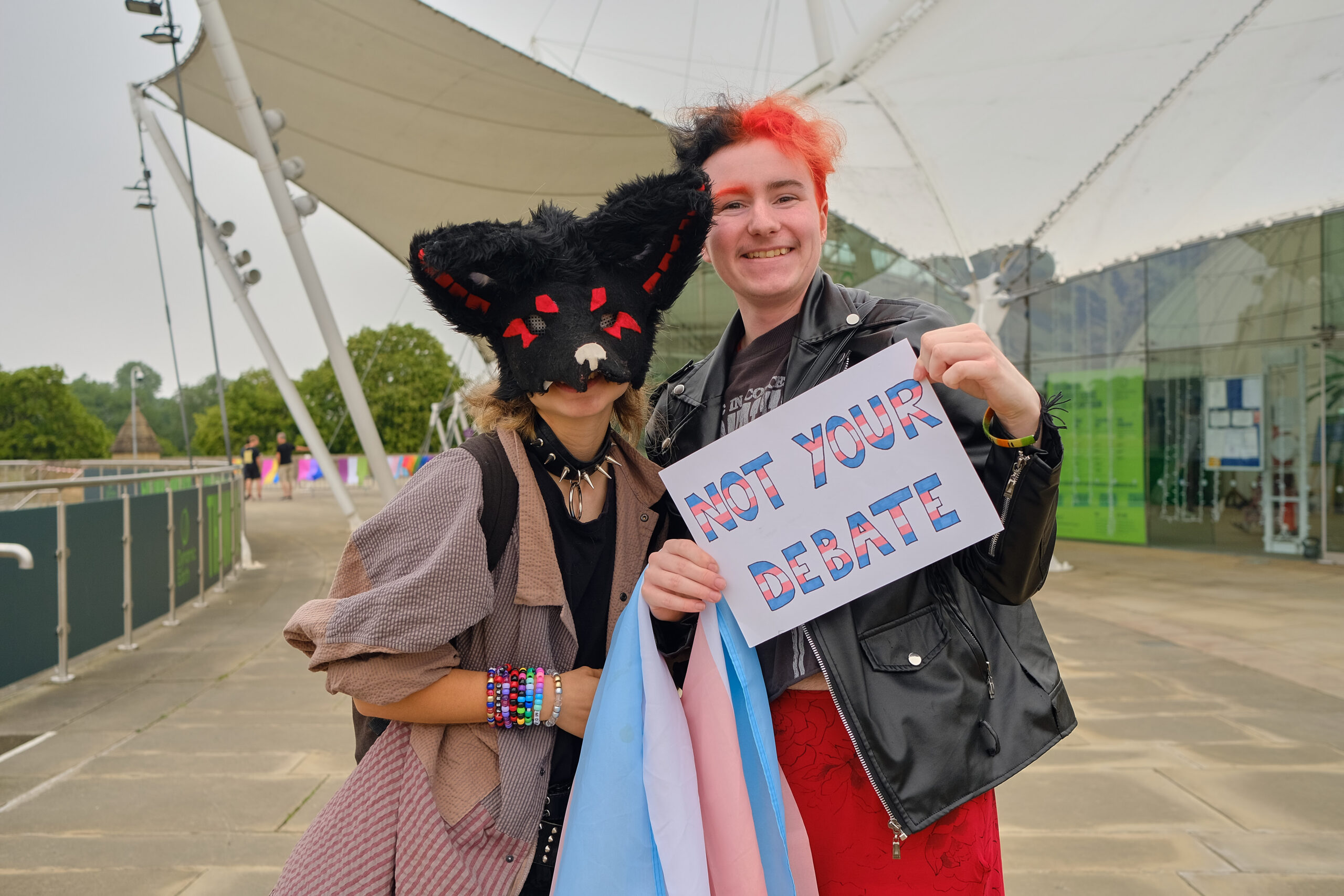 Two people at our Pride Breakfast event in Edinburgh holding a sign that says "not your debate"