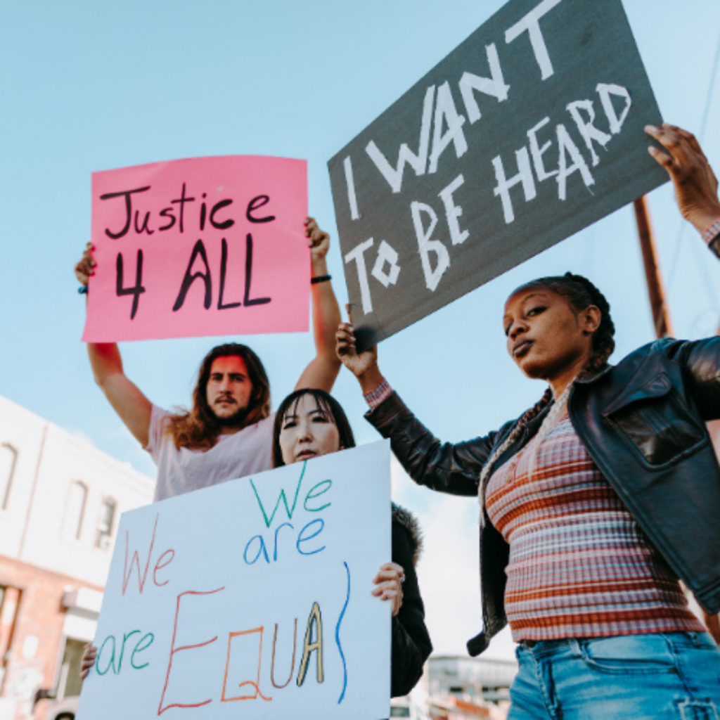 Three protestors holding signs: Justice 4 All;We All Are EquaI; I Want To Be Heard